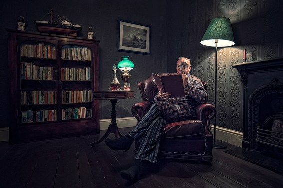 old man looking through a magnifying glass